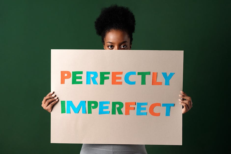 kobieta trzymająca w rękach kartkę z napisem "Perfectly impefrect"