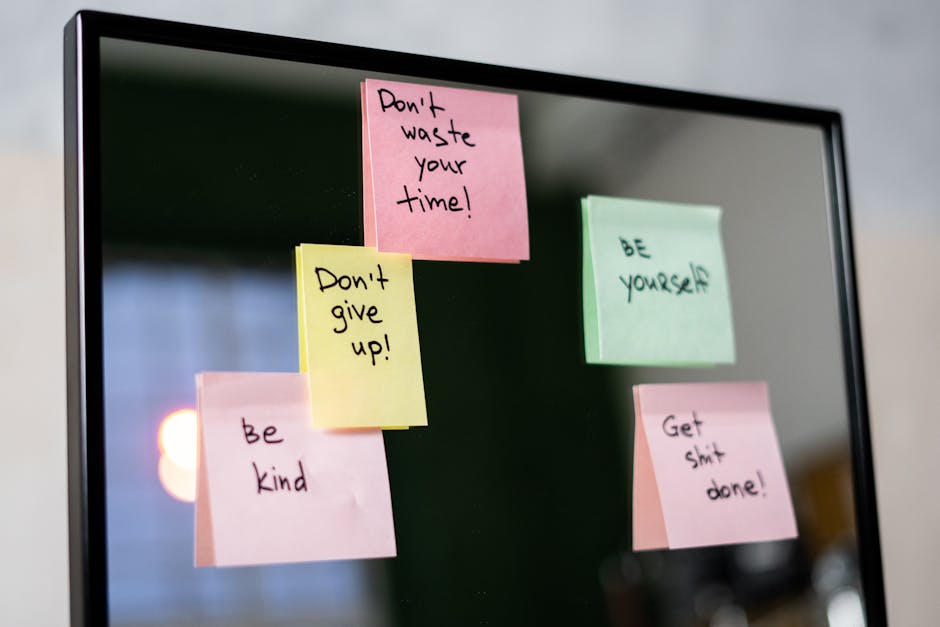 sticky notes z motywującymi hasłami przyczepione do ekranu komputera